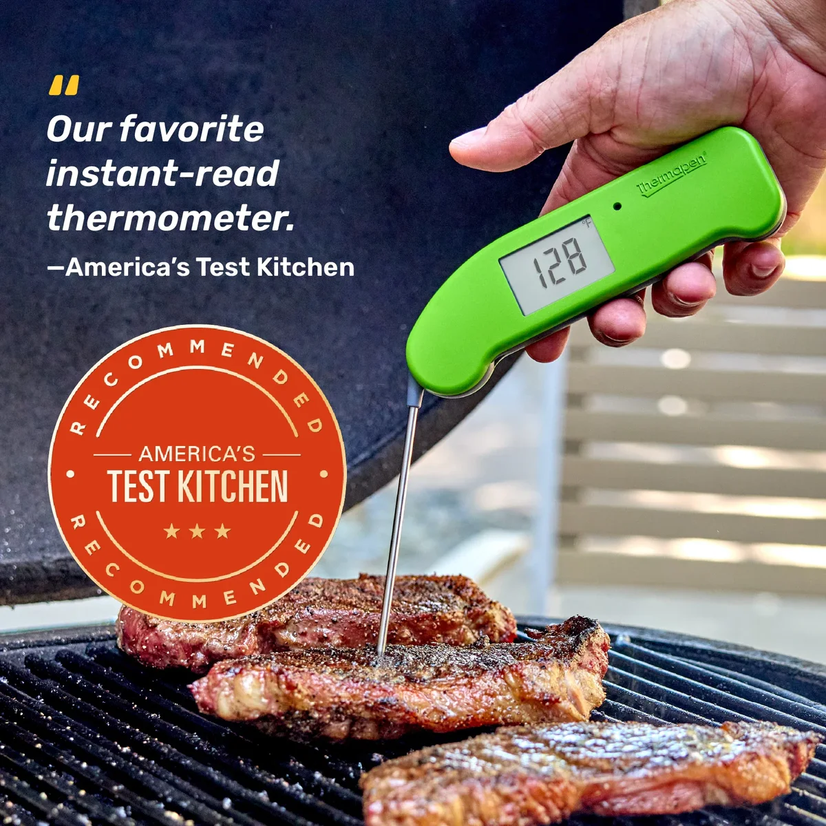 Red ThermoWorks Thermapen ONE checking the internal temperature of steaks on a charcoal grill, reading 125 degrees F