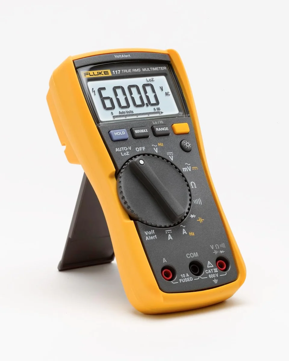 Fluke 117 multimeter shown at a three-quarter angle with its rear kickstand deployed, LCD reading 600.0 V AC