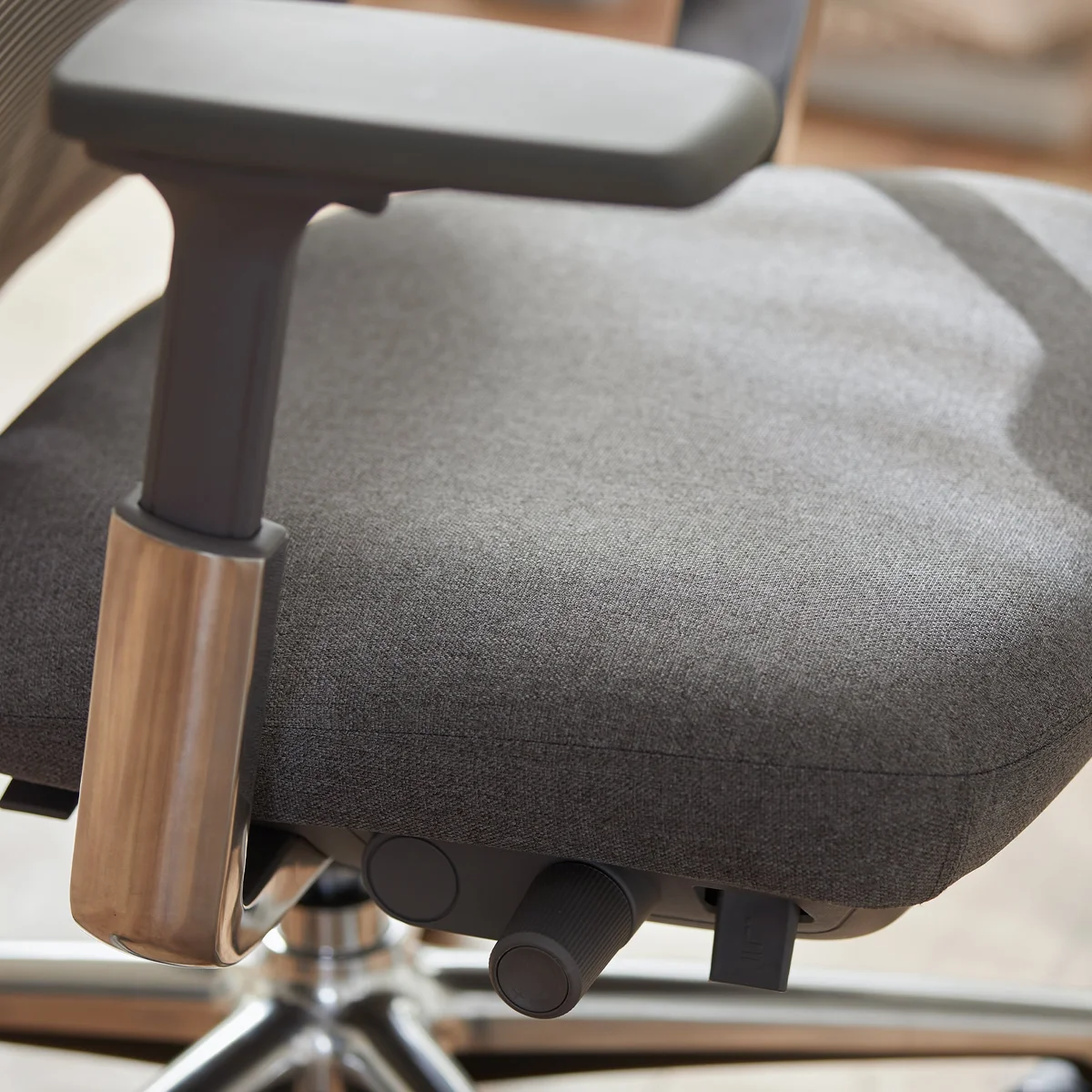 Colamy Atlas seat cushion and armrest close-up showing fabric texture and chrome arm mechanism