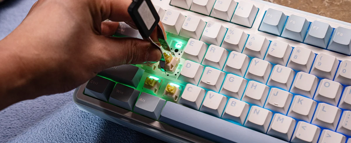 Aula F75 close-up of hot-swappable switch being pulled with green RGB backlighting visible