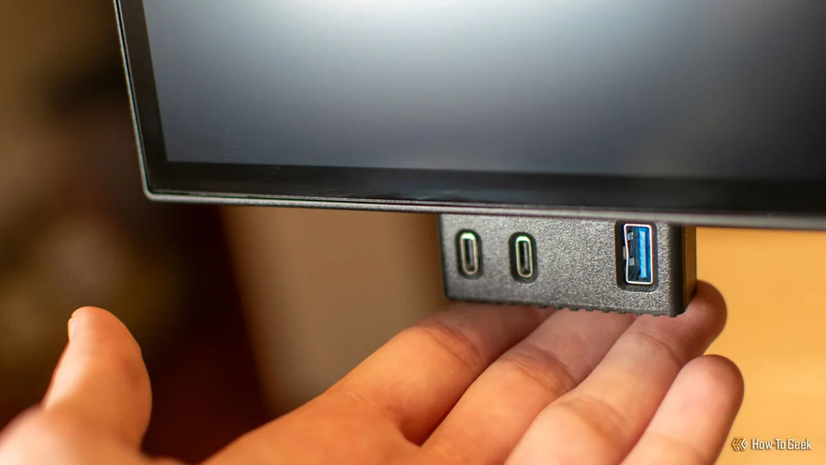 Dell U2725QE pop-out quick-access port with 2x USB-C and 1x USB-A being pulled down by hand