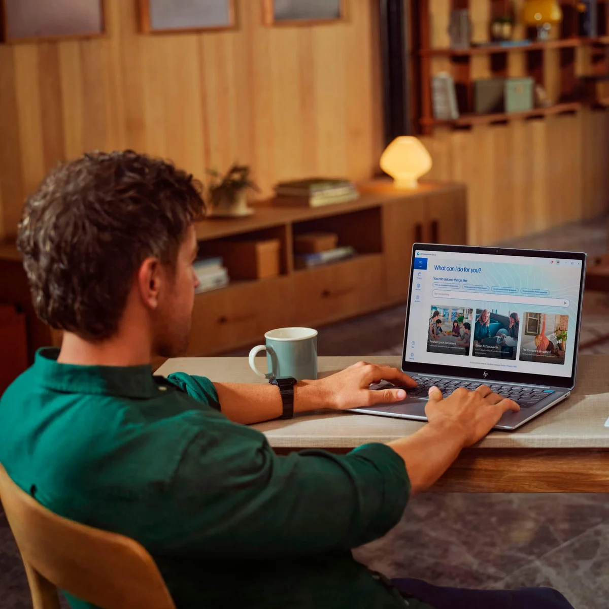 Man using HP OmniBook Ultra at a home desk, viewed from behind showing the display
