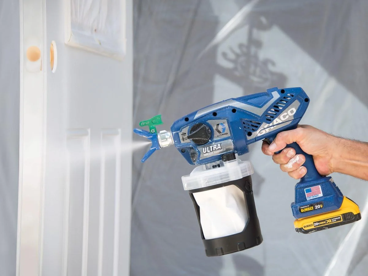Graco Ultra Cordless 17M363 spraying white paint on an interior door and trim