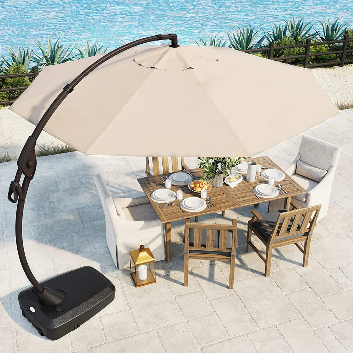 Grand Patio Napoli beige cantilever umbrella over a wooden dining table with place settings on a stone patio