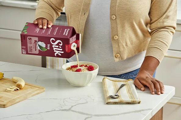 Silk Organic Unsweetened Soy Milk benefits lifestyle photo showing the carton with soybeans
