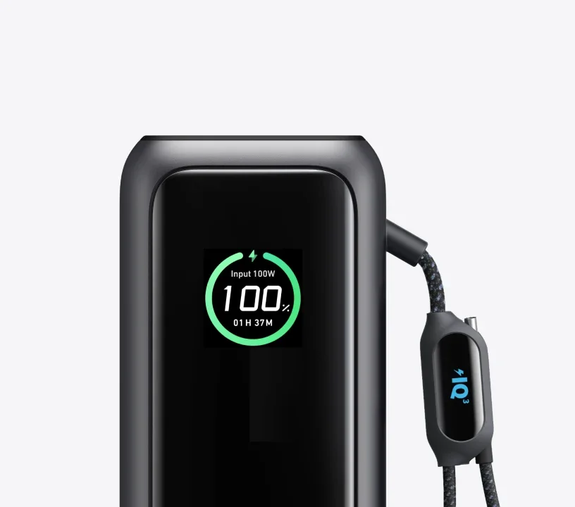 Close-up of the Anker Laptop Power Bank 165W smart display showing 100W input, 100% charge and time remaining, beside the braided cable's connector display