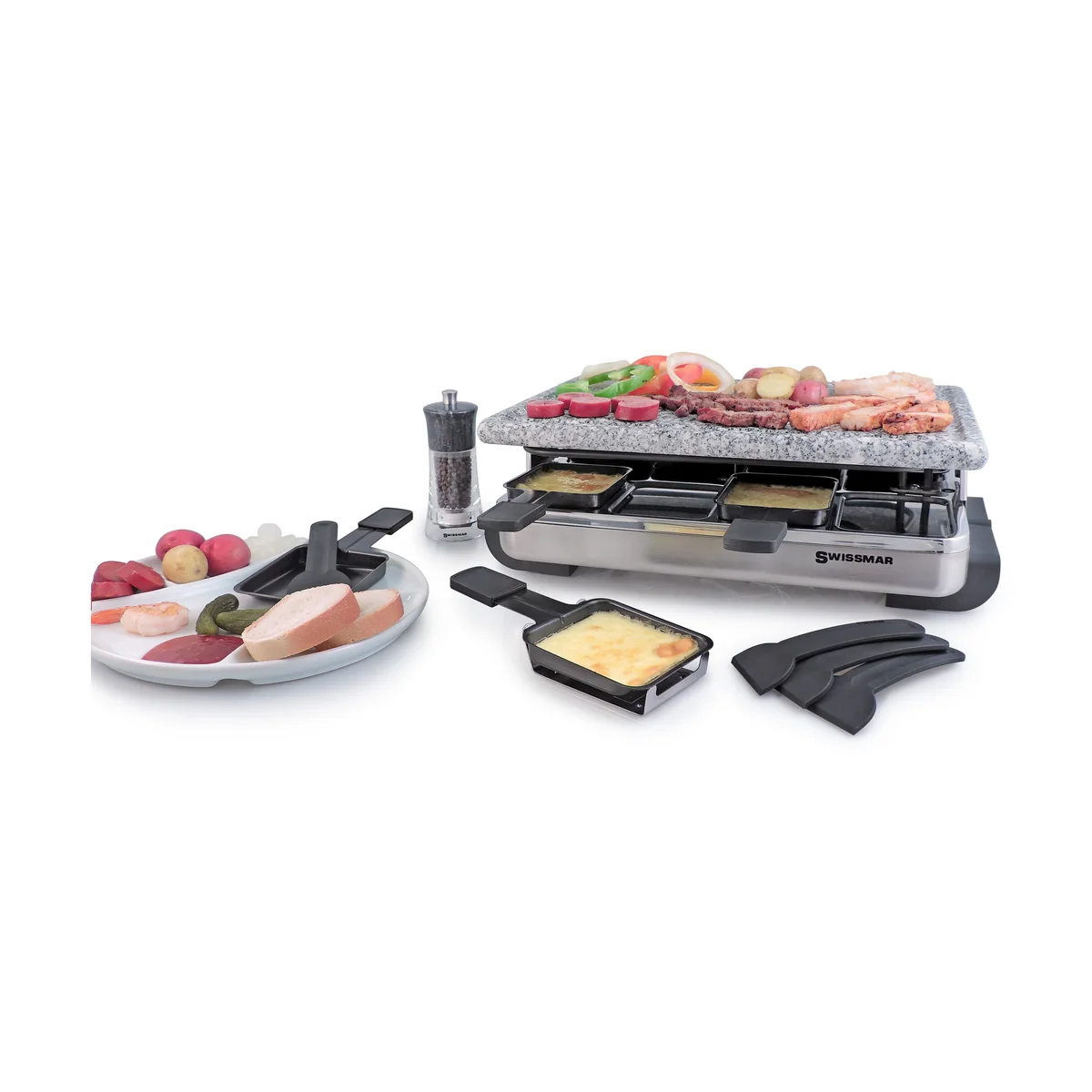 Swissmar Stelvio granite-top raclette grill in use with meats and vegetables on the stone, melted cheese in the raclette pans, spatulas and a platter of potatoes and bread