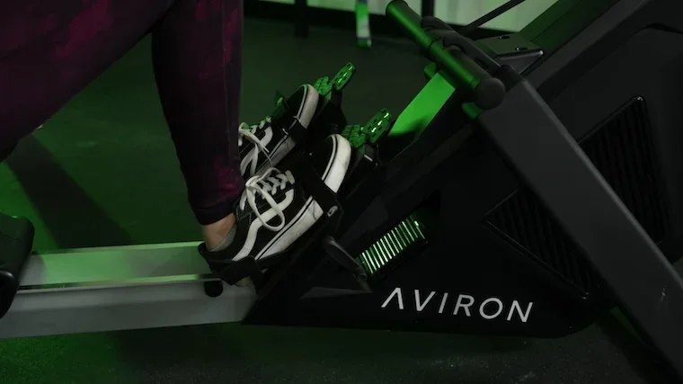 Aviron Strong Series footrest close-up with feet strapped in and Aviron branding