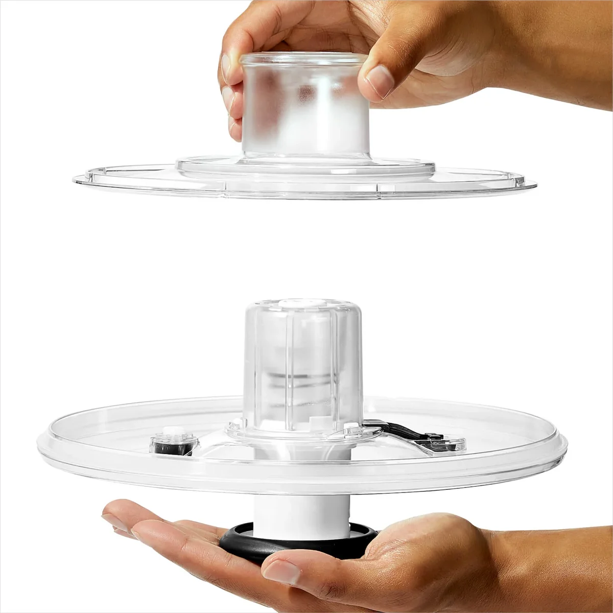 OXO Steel Salad Spinner clear lid taken apart into two halves for cleaning, showing the pump mechanism, spring and brake button