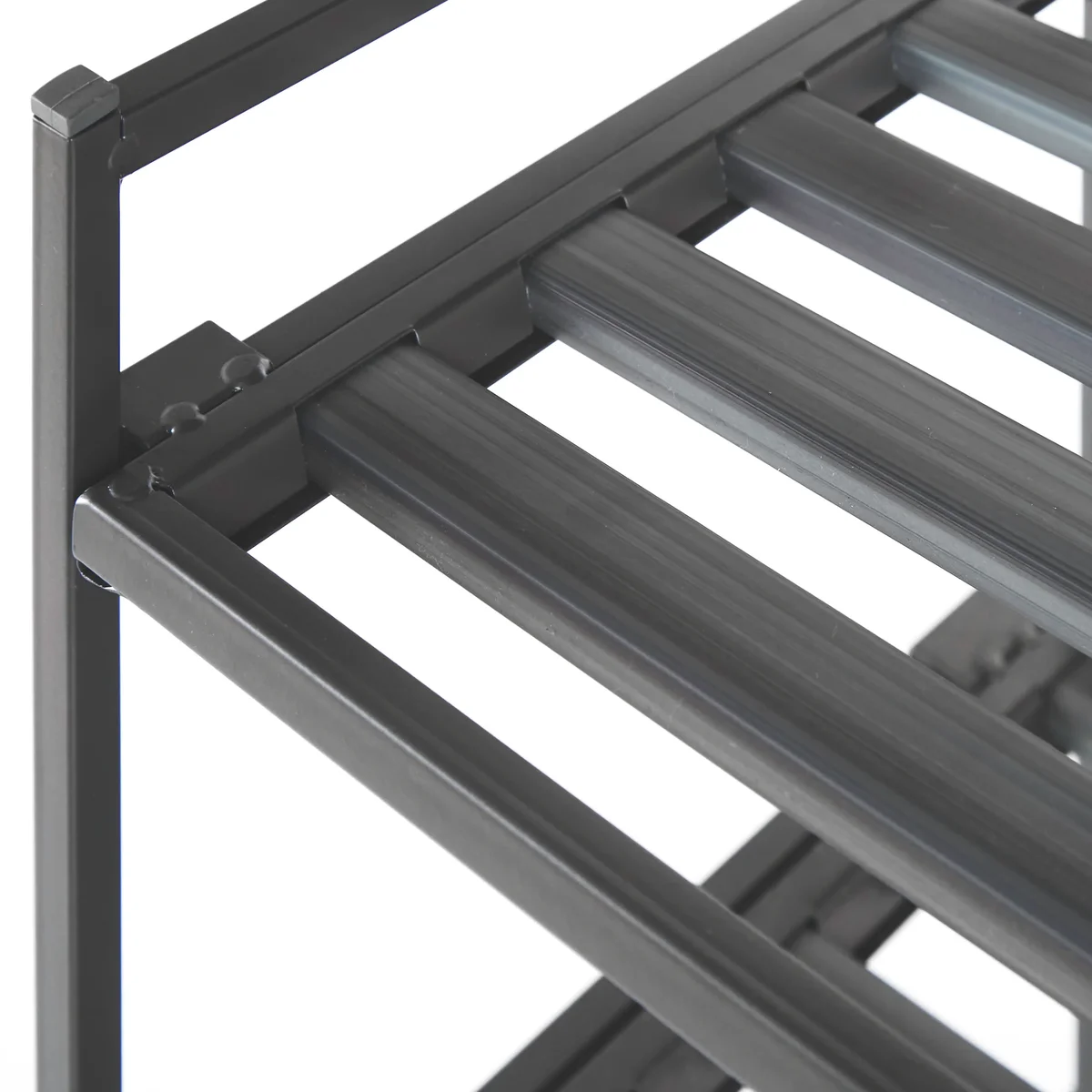 Close-up of the Seville Classics 3-Tier Shoe Rack's ribbed resin slats seated in the steel shelf frame beside a corner post
