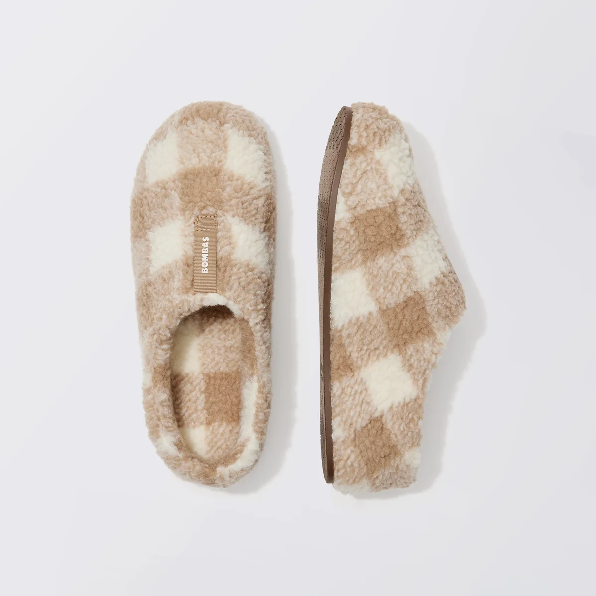 Bombas Sunday Slipper pair, top-down and side view showing the sherpa lining, BOMBAS heel pull tab, and open-back design