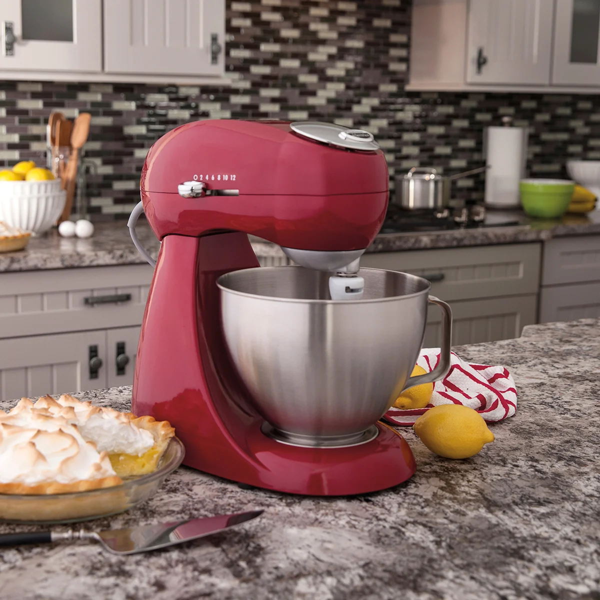 Hamilton Beach Eclectrics stand mixer in use on a kitchen counter alongside a lemon meringue pie and fresh lemons