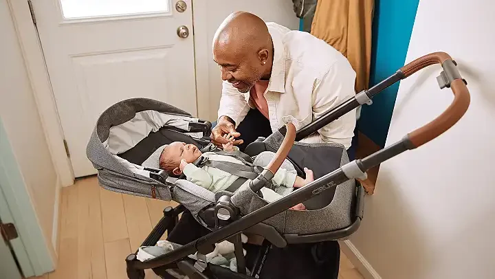 UPPAbaby Cruz V3 with newborn in near-flat reclined seat, parent smiling at baby
