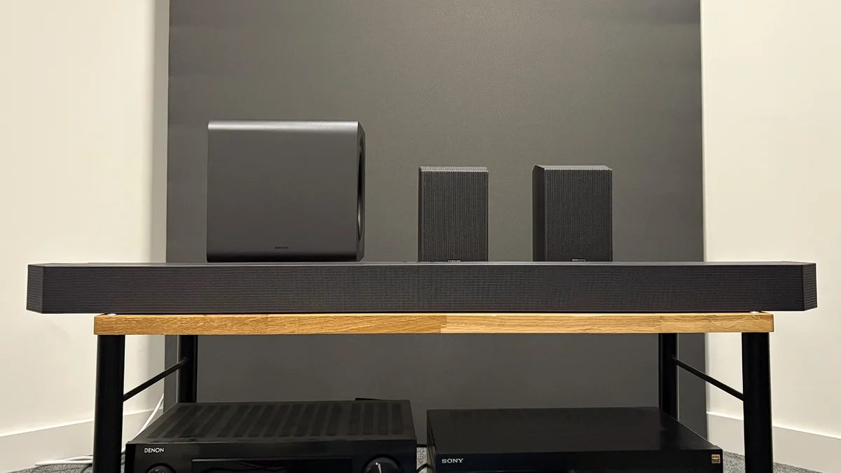 Samsung HW-Q990F soundbar, subwoofer, and rear speakers arranged on a test bench — front view
