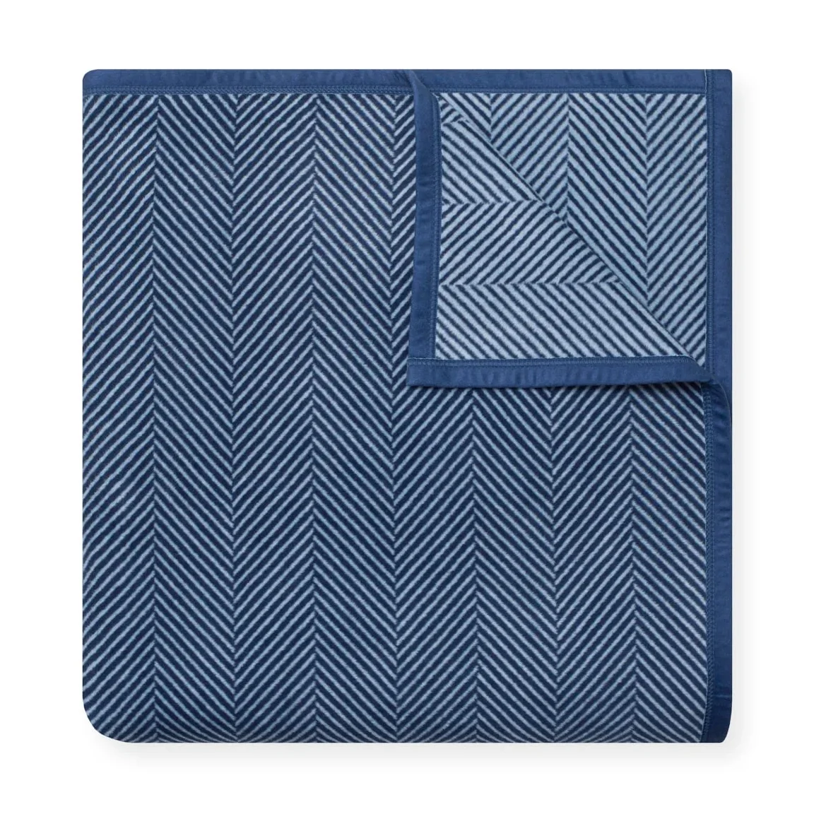 ChappyWrap Harborview Herringbone blanket folded and fanned, showing the herringbone pattern and navy trim