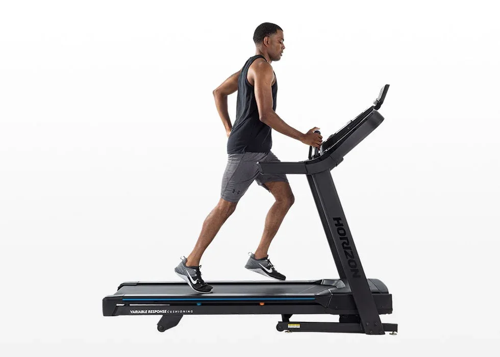 Man running on Horizon 7.0 AT treadmill at incline, side profile view
