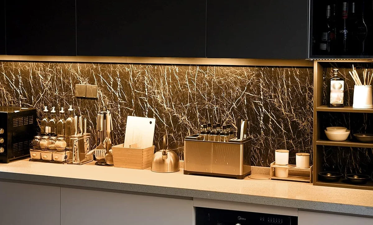 Litever under-cabinet bars lighting a dark marble backsplash and a long run of kitchen counter