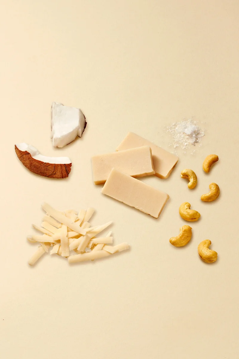 Miyoko's mozzarella ingredients flat lay with cashews, coconut, cheese slices and sea salt