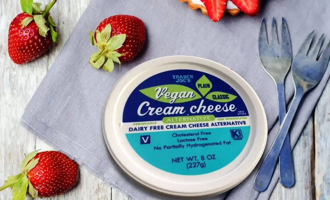 Trader Joe's Vegan Cream Cheese Alternative tub lid viewed from above on a gray linen cloth with fresh strawberries