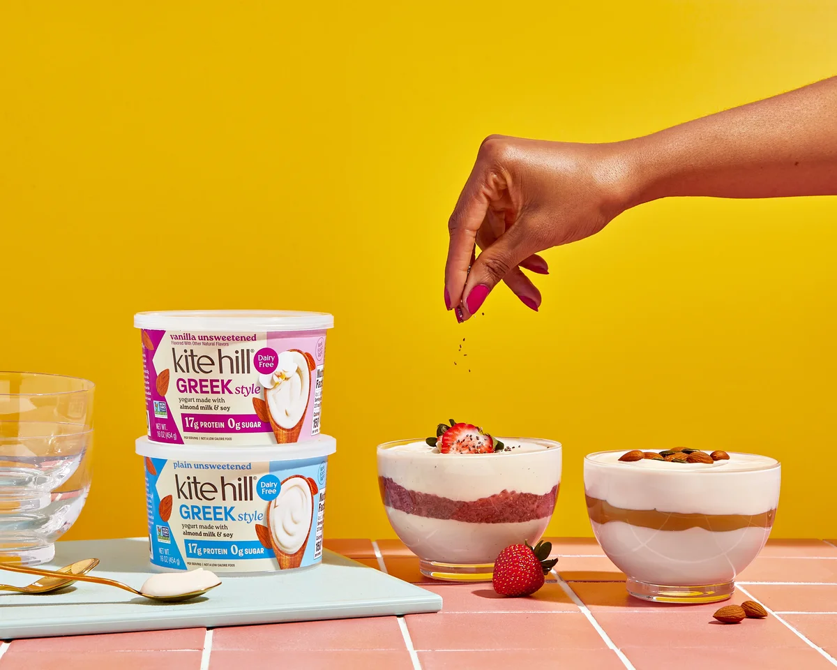 Kite Hill Greek-Style plain and vanilla containers with yogurt parfait glasses