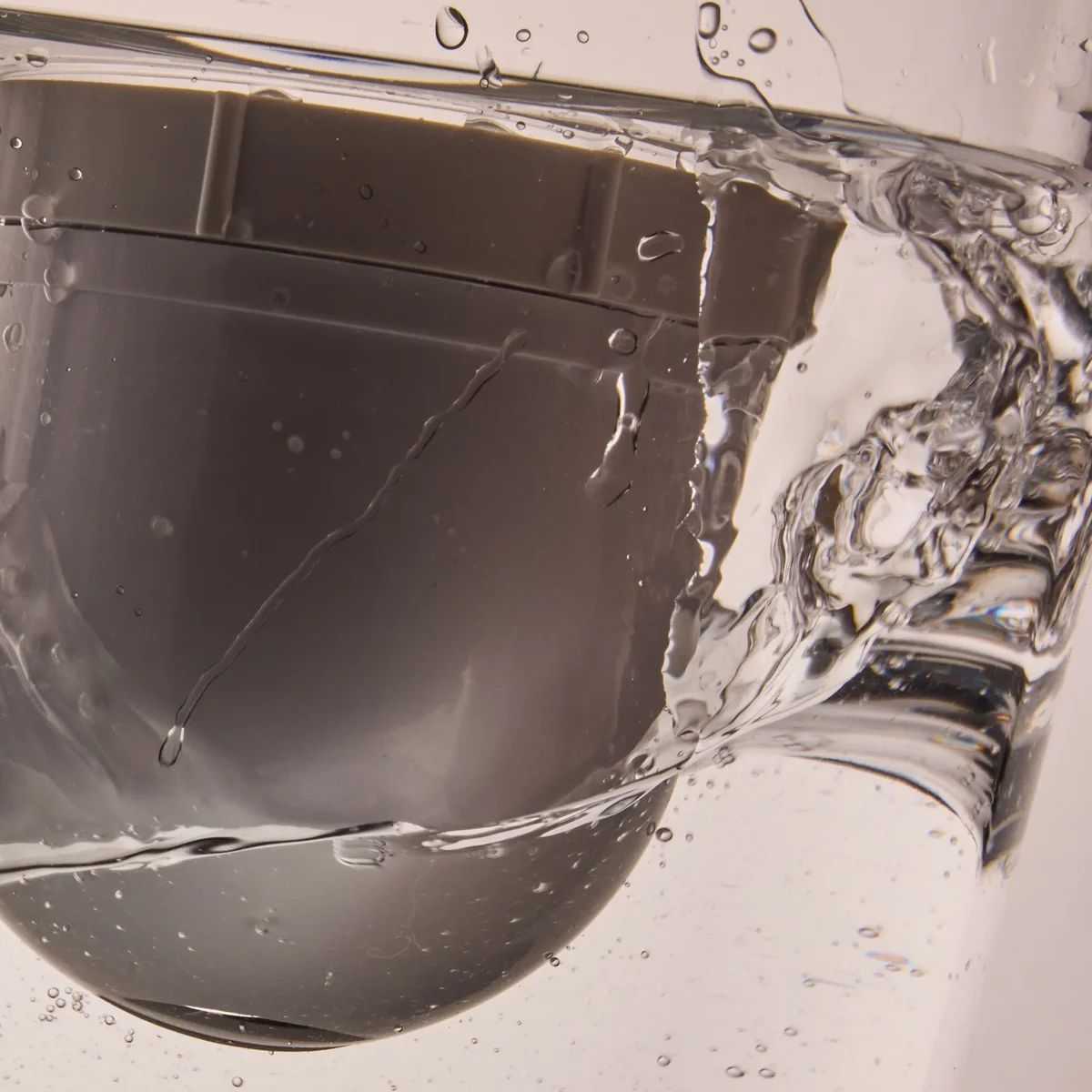 Clearly Filtered pitcher filter capsule submerged in water, close-up view