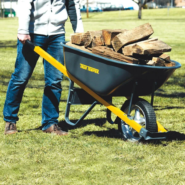 True Temper R6STSP14 wheelbarrow loaded with firewood, in-use lifestyle shot on grass