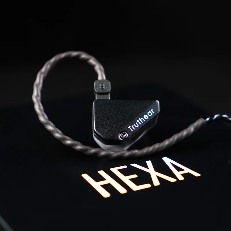 Truthear Hexa earpiece with coiled silver-plated cable resting on the HEXA branded carrying case